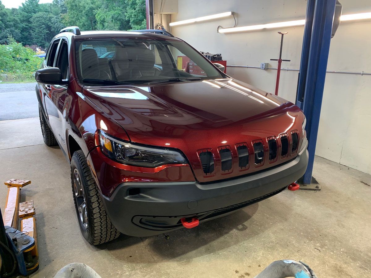 After: repaired red Jeep Cherokee inside Gino's Collision Center